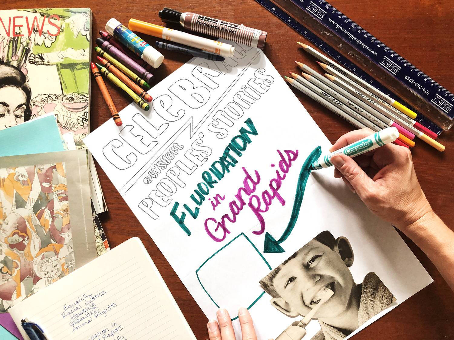 Image of hands working on creating a poster.